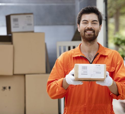 smiling-young-delivery-man-preparing-parcels-delivery