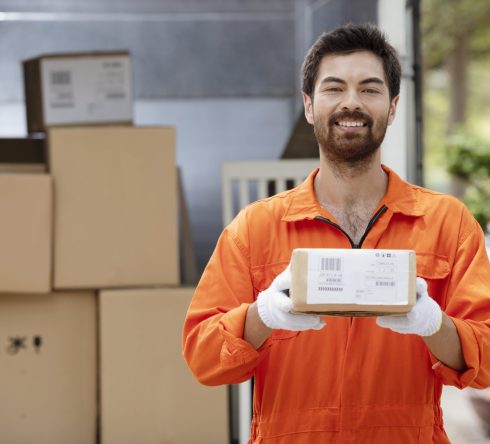 smiling-young-delivery-man-preparing-parcels-delivery smiling-young-delivery-man-preparing-parcels-delivery